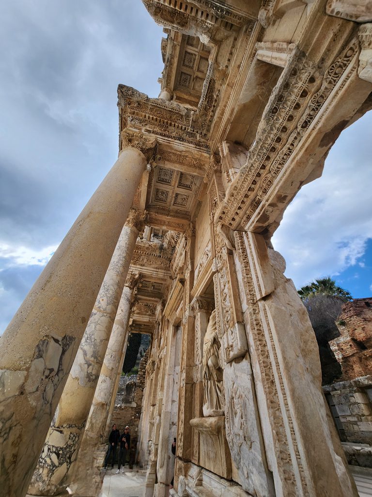 켈수스 도서관 (Library of Celsus) 기둥. 기둥 머리의 화려한 코린트식 양식과 천장 석조물에 새겨진 정교한 기하학적 격자무늬(카세트 천장) 조각들이 고대 로마인들의 경이로운 건축 기술을 생생하게 보여줍니다. 기둥 사이 벽면에 배치된 여신상(지혜, 미덕, 지식, 통찰력을 상징하는 4대 여신상 중 하나)의 부조가 로마 예술의 섬세함과 우아함을 극대화시켜 줍니다.