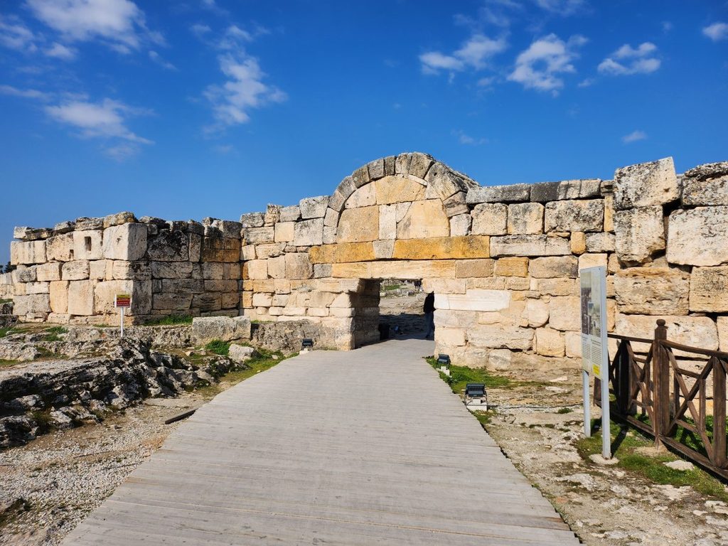 Passing through the clean ticket barriers, we walked along a manicured wooden boardwalk until we met the imposing South Byzantine Gate (the southern city wall), meticulously engineered from massive interlocking blocks of stone. Passing through this grand Roman bulwark feels like stepping through a time machine, instantly dropping you into a thriving ancient spa city.