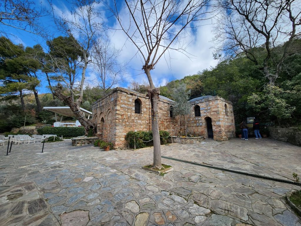 A view of the House of the Virgin Mary, a modest stone structure nestled in the woods. Built around the 4th century, the building was discovered and restored based on the visions of the 19th-century nun Anne Catherine Emmerich; it attracts many pilgrims annually for Mass.