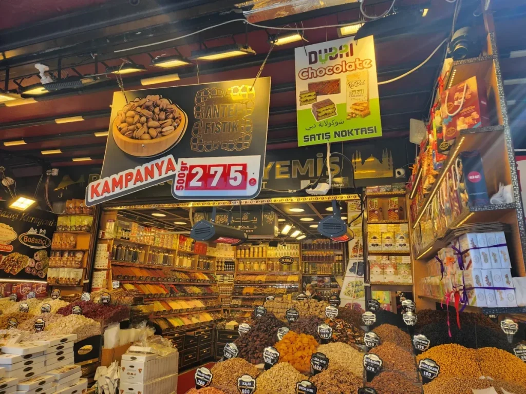 상점 내부의 화려한 디스플레이입니다. 전 세계적으로 유행한 두바이 초콜릿(Dubai Chocolate) 판매처라는 노란색 광고판도 눈에 띕니다.